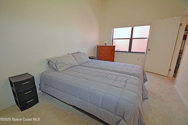 bedroom featuring baseboards and light tile patterned floors