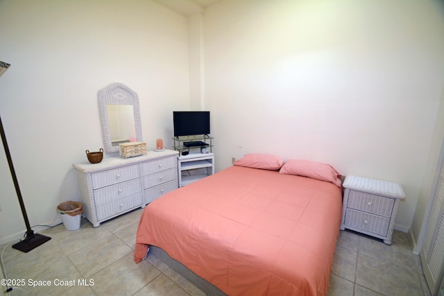 bedroom featuring light tile patterned flooring and baseboards