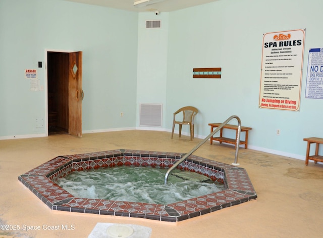 living area with baseboards, visible vents, and a hot tub