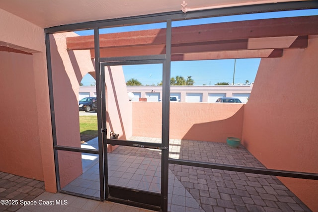 doorway with a textured wall and floor to ceiling windows