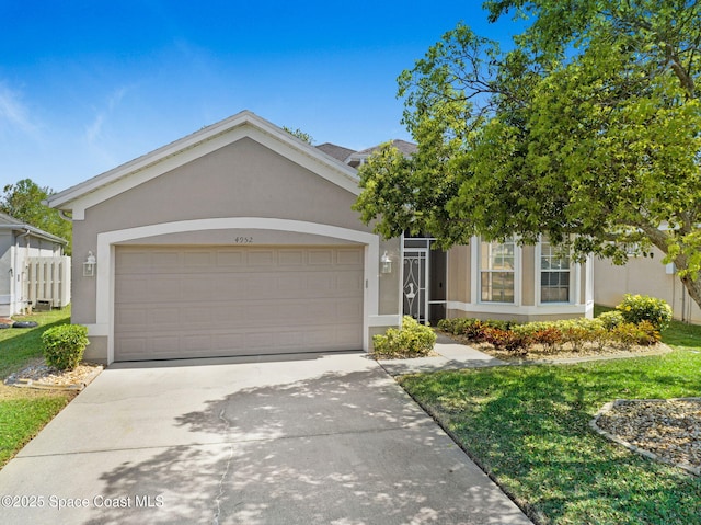 view of front facade with concrete driveway, an attached garage, a front yard, and stucco siding