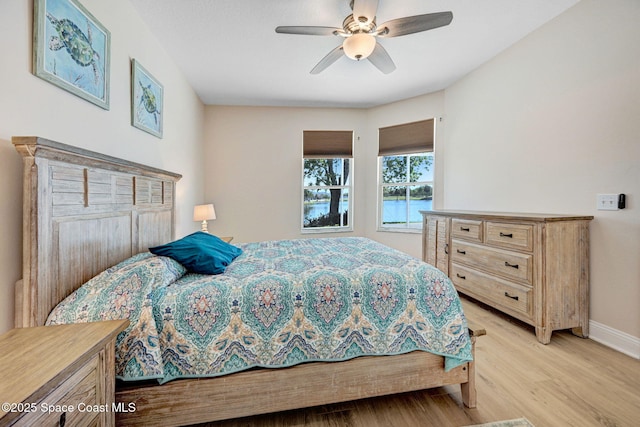 bedroom with baseboards, light wood-style flooring, and a ceiling fan