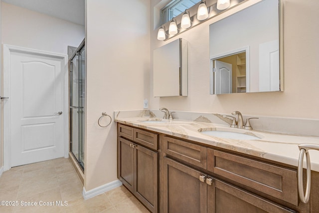 bathroom with tile patterned flooring, a stall shower, double vanity, and a sink