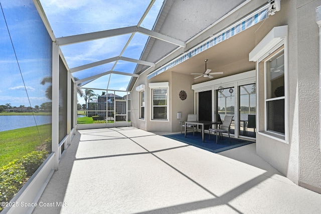 unfurnished sunroom featuring a water view and ceiling fan