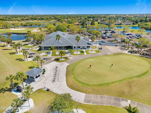 drone / aerial view featuring golf course view and a water view