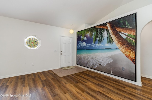 foyer entrance with vaulted ceiling, dark wood-style flooring, and baseboards