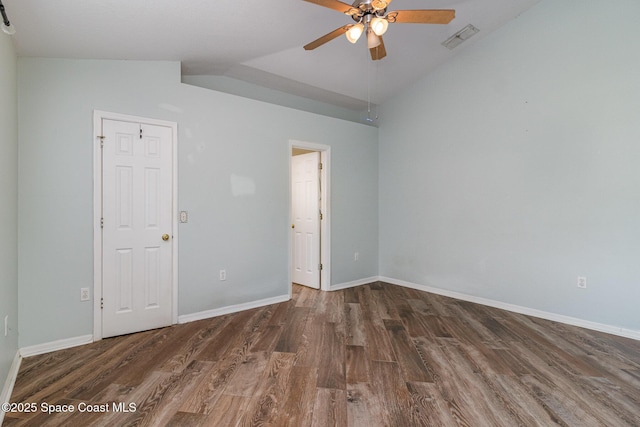 unfurnished bedroom featuring dark wood-type flooring, visible vents, vaulted ceiling, and baseboards