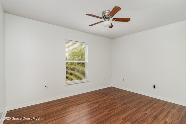 spare room with dark wood-style floors, ceiling fan, and baseboards