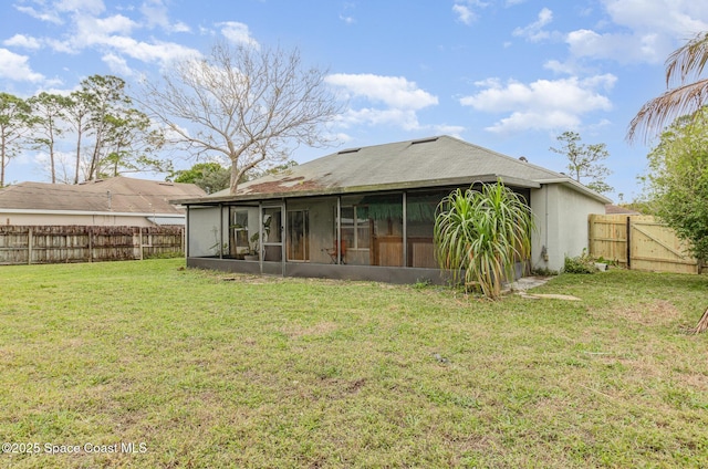 back of house featuring a sunroom, a fenced backyard, a gate, and a yard