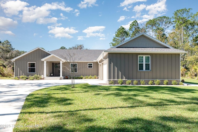 view of front of property featuring a garage, driveway, board and batten siding, and a front yard