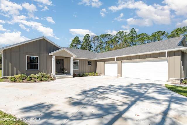 ranch-style home with board and batten siding, driveway, a shingled roof, and an attached garage