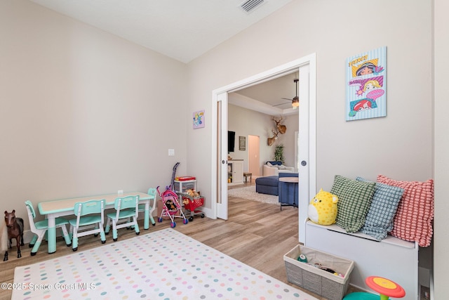 rec room with visible vents, ceiling fan, baseboards, and wood finished floors