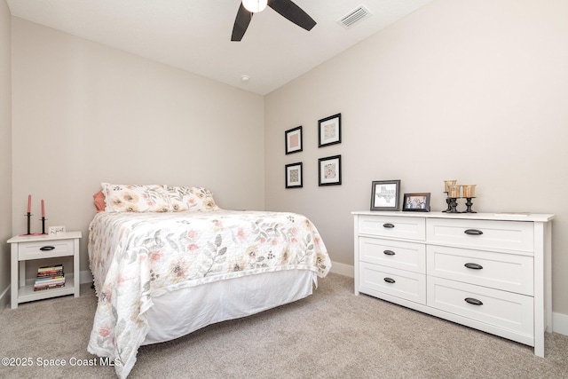 bedroom featuring light carpet, visible vents, baseboards, lofted ceiling, and ceiling fan