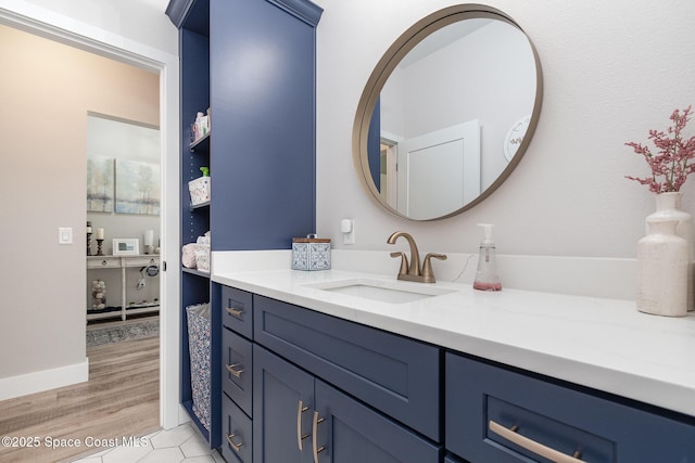 bathroom with vanity, baseboards, and wood finished floors