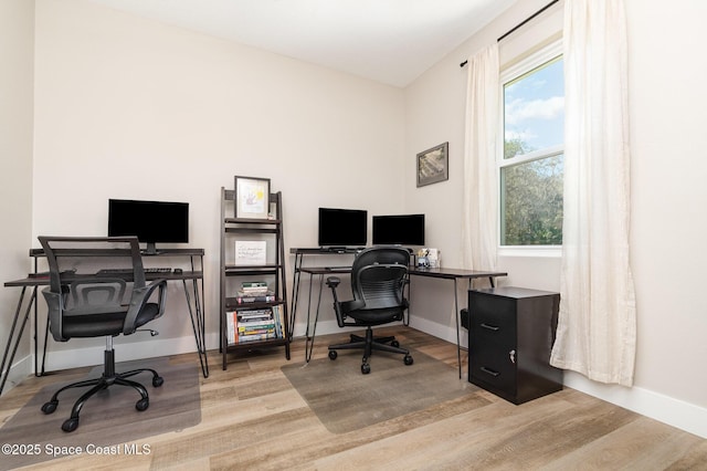 home office with baseboards and wood finished floors