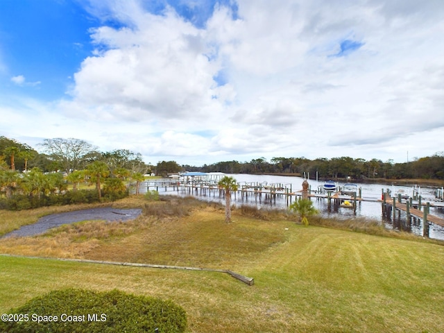 dock area featuring a water view, a yard, and boat lift