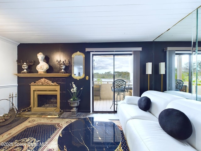 living area featuring a fireplace with raised hearth, plenty of natural light, and wood finished floors