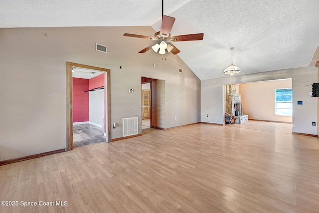 unfurnished living room with a textured ceiling, light wood-type flooring, and visible vents