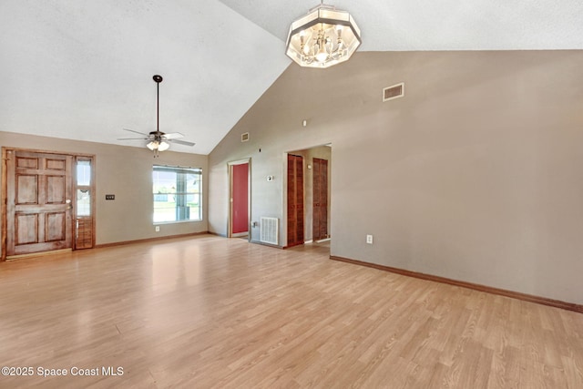 unfurnished living room with ceiling fan with notable chandelier, baseboards, visible vents, and light wood-style floors