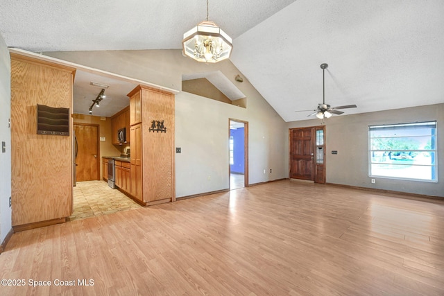 unfurnished living room with a textured ceiling, ceiling fan with notable chandelier, light wood-style flooring, and baseboards