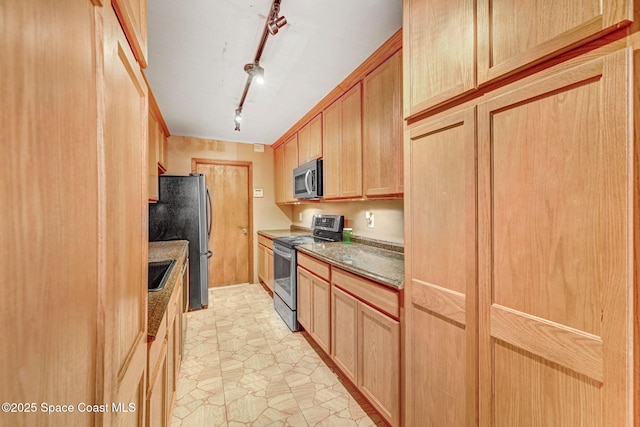 kitchen featuring stone counters, light brown cabinets, a sink, appliances with stainless steel finishes, and rail lighting