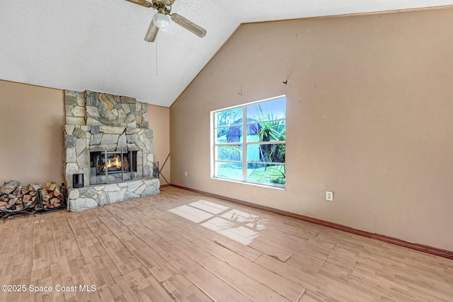 unfurnished living room featuring a textured ceiling, light wood-style flooring, a fireplace, and a ceiling fan