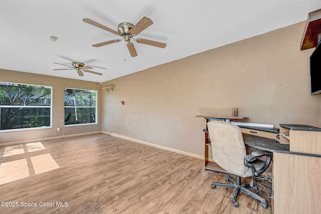 unfurnished office with ceiling fan, baseboards, and wood finished floors