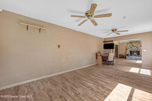 interior space featuring a fireplace, baseboards, and wood finished floors