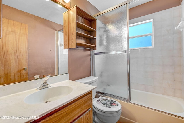 bathroom featuring enclosed tub / shower combo, vanity, and toilet