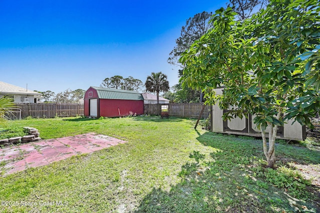 view of yard featuring a patio area, a shed, an outdoor structure, and a fenced backyard