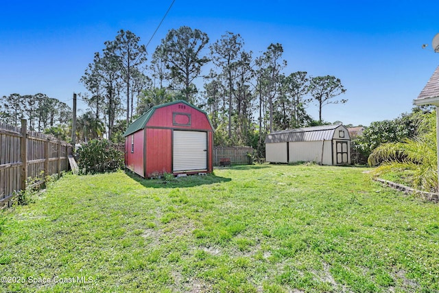 view of yard featuring a storage shed, an outdoor structure, and a fenced backyard