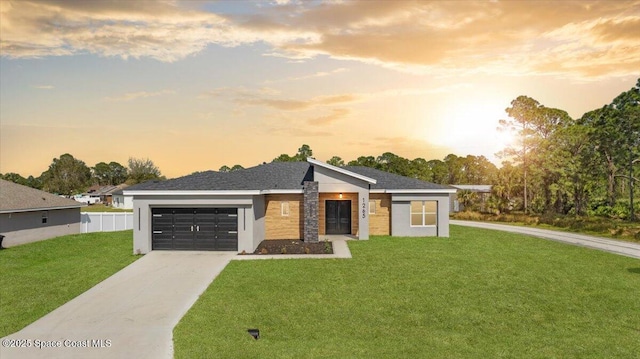 view of front of home featuring driveway, an attached garage, fence, and a front yard