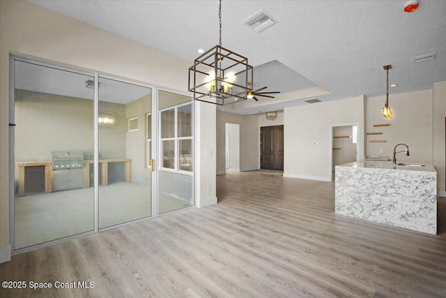 unfurnished dining area with visible vents, a sink, and wood finished floors