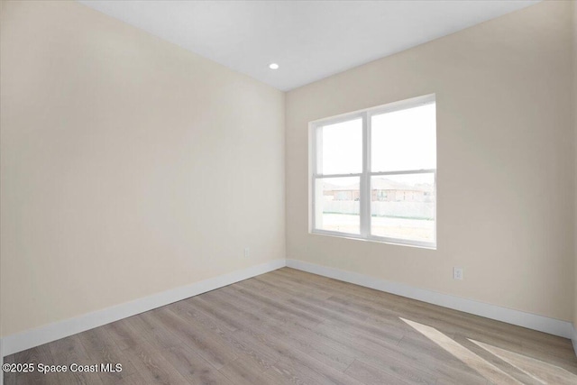 empty room featuring light wood-style flooring, baseboards, and recessed lighting