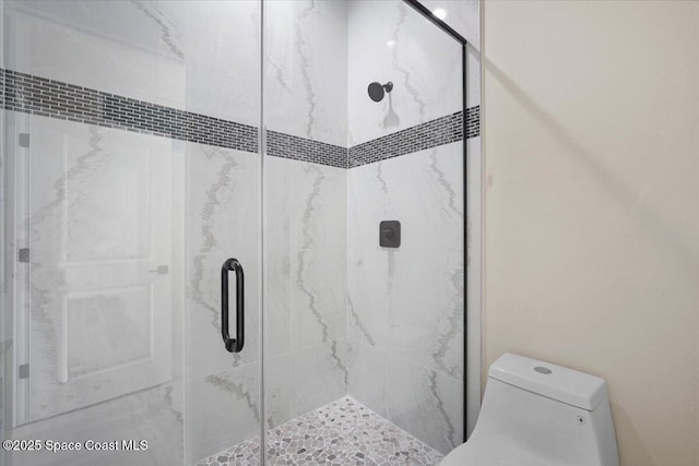 bathroom featuring a shower stall and toilet