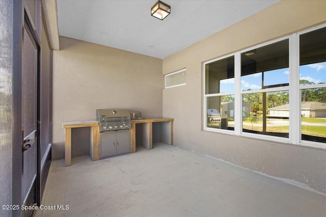 view of patio featuring exterior kitchen and a grill