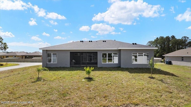 back of house featuring a lawn and stucco siding