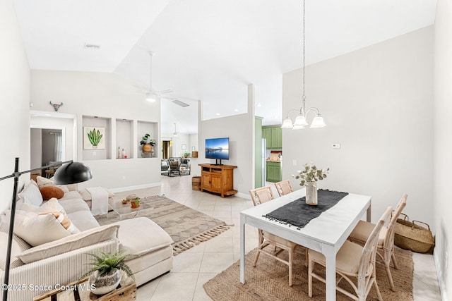 living area featuring visible vents, light tile patterned flooring, high vaulted ceiling, baseboards, and ceiling fan with notable chandelier