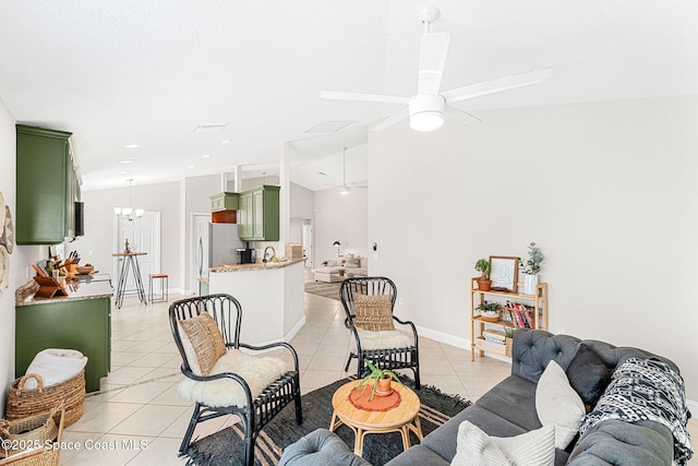 living area featuring lofted ceiling, light tile patterned floors, baseboards, and ceiling fan with notable chandelier