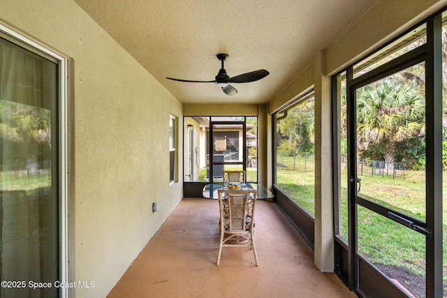 unfurnished sunroom featuring a ceiling fan