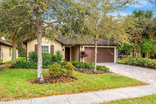 ranch-style house with a garage, a shingled roof, decorative driveway, a front lawn, and stucco siding