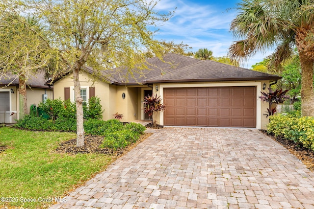 single story home featuring a garage, roof with shingles, decorative driveway, a front lawn, and stucco siding