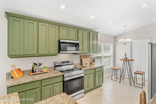 kitchen featuring light tile patterned flooring, vaulted ceiling, appliances with stainless steel finishes, decorative light fixtures, and green cabinetry