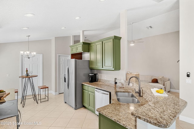 kitchen with stainless steel appliances, green cabinetry, a sink, and a peninsula