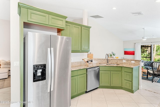 kitchen featuring stainless steel appliances, vaulted ceiling, a sink, green cabinetry, and a peninsula