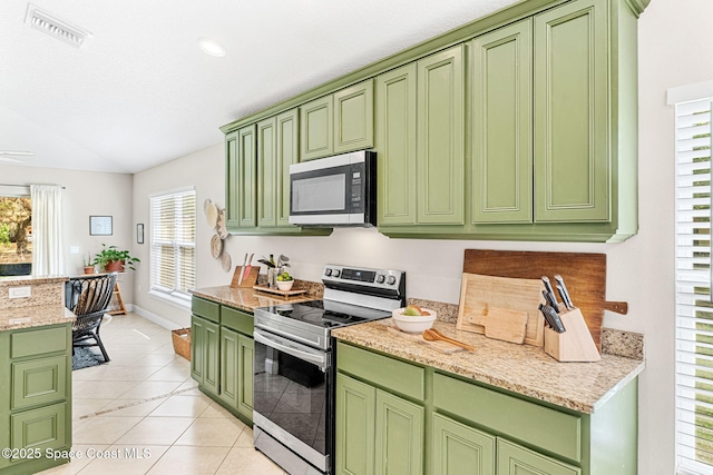 kitchen featuring stainless steel appliances, visible vents, light tile patterned flooring, light stone countertops, and green cabinetry