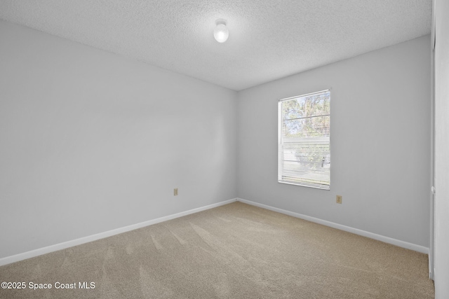 carpeted spare room with baseboards and a textured ceiling