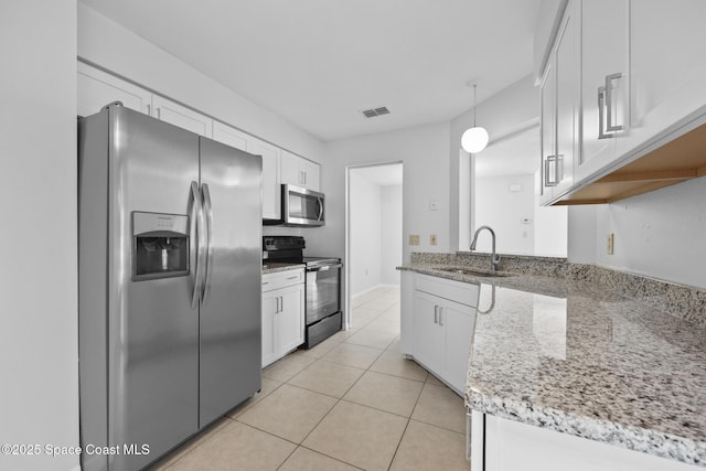 kitchen featuring light stone counters, pendant lighting, stainless steel appliances, white cabinetry, and a sink