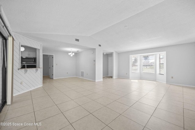 unfurnished living room with light tile patterned floors, visible vents, lofted ceiling, a textured ceiling, and a chandelier