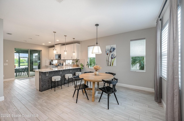 dining room featuring light wood finished floors, recessed lighting, and baseboards